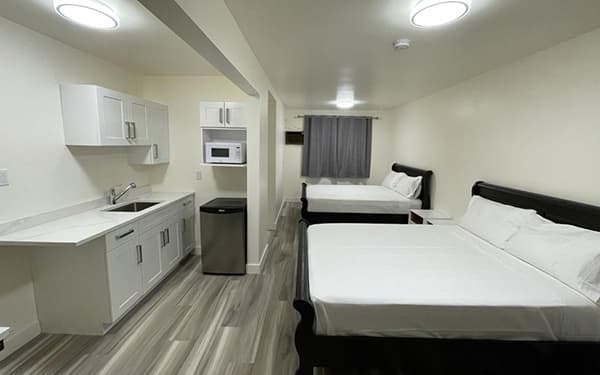 Renovated guest room with two queen beds and a kitchenette
